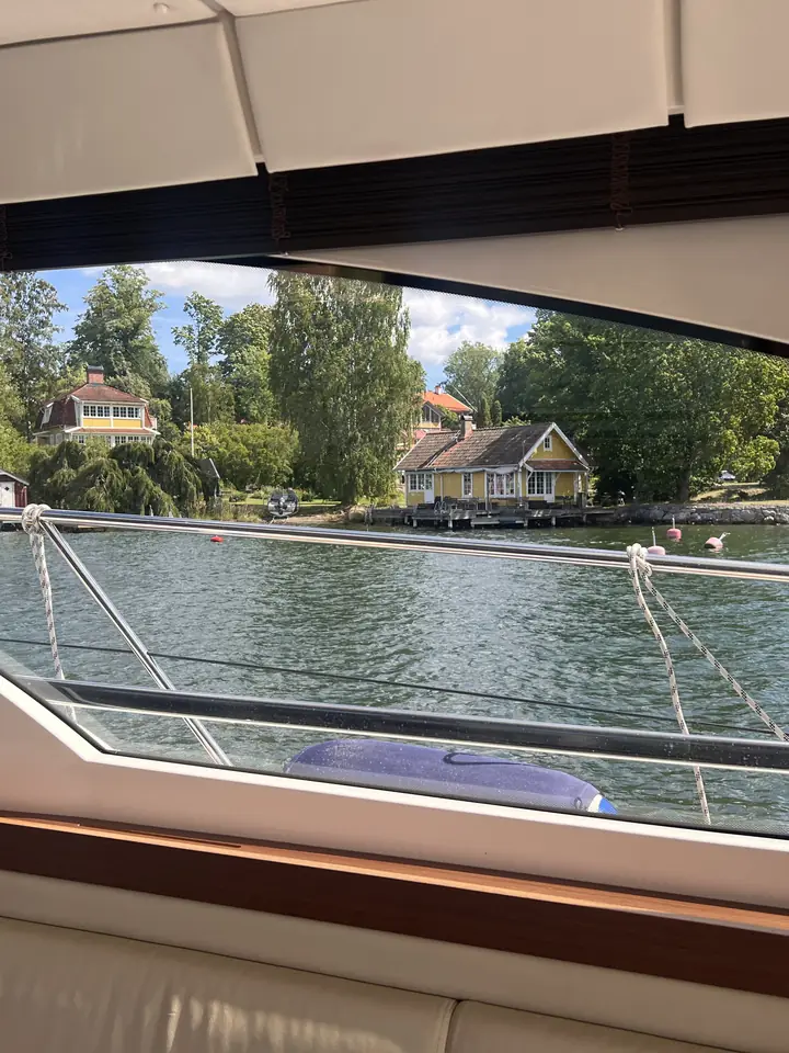 Röda skärgårdsstugor genom salongsfönstret